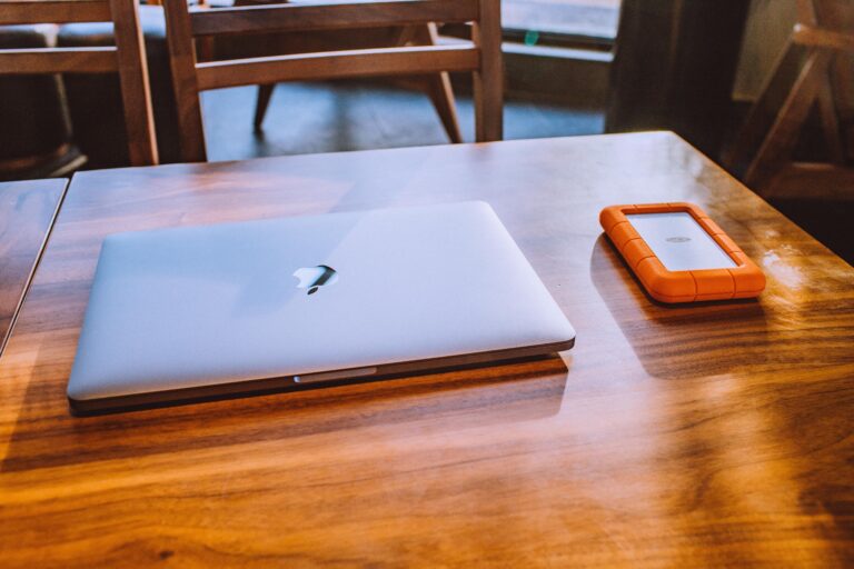 Laptop beside portable storage used for website backup