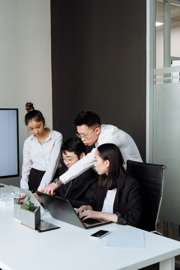 Professional team collaborating around a laptop on website support