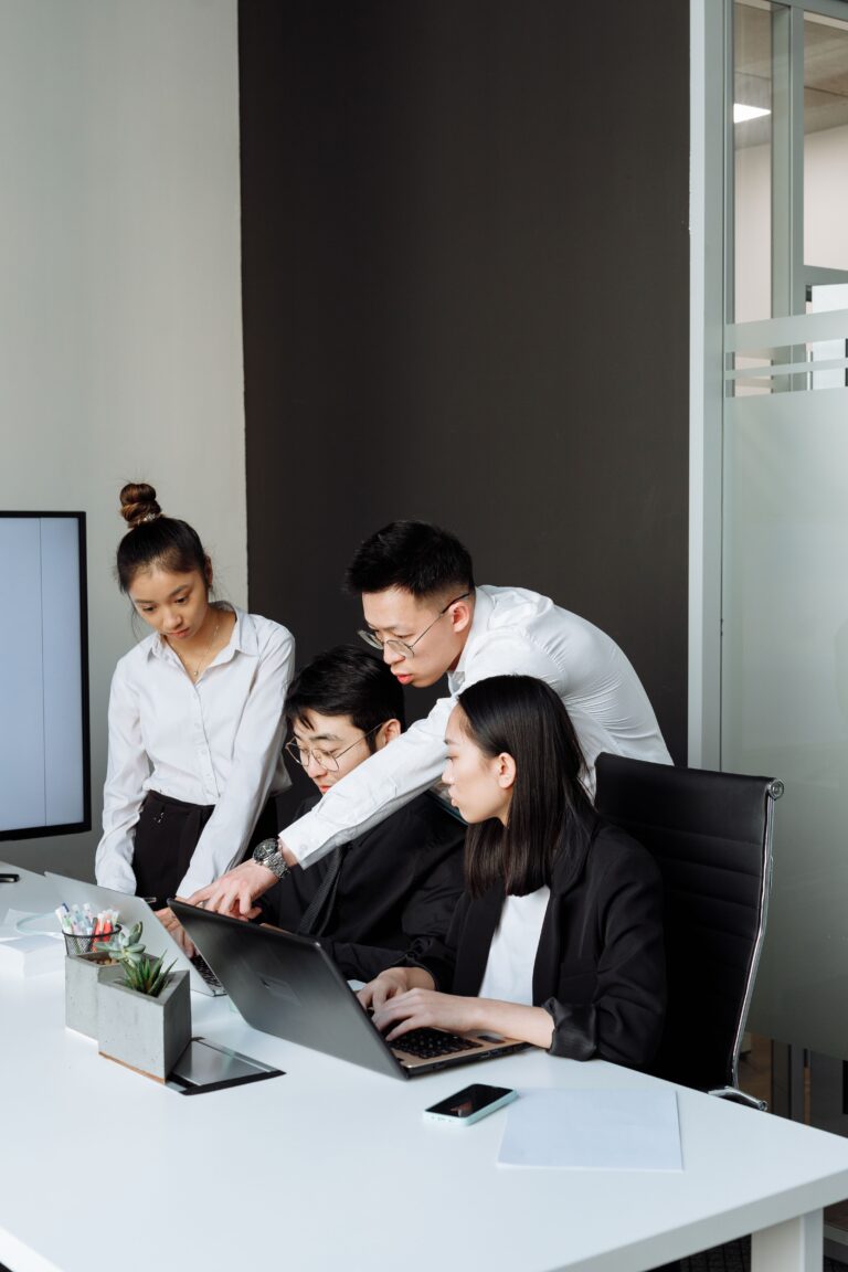 Professional team collaborating around a laptop on website support