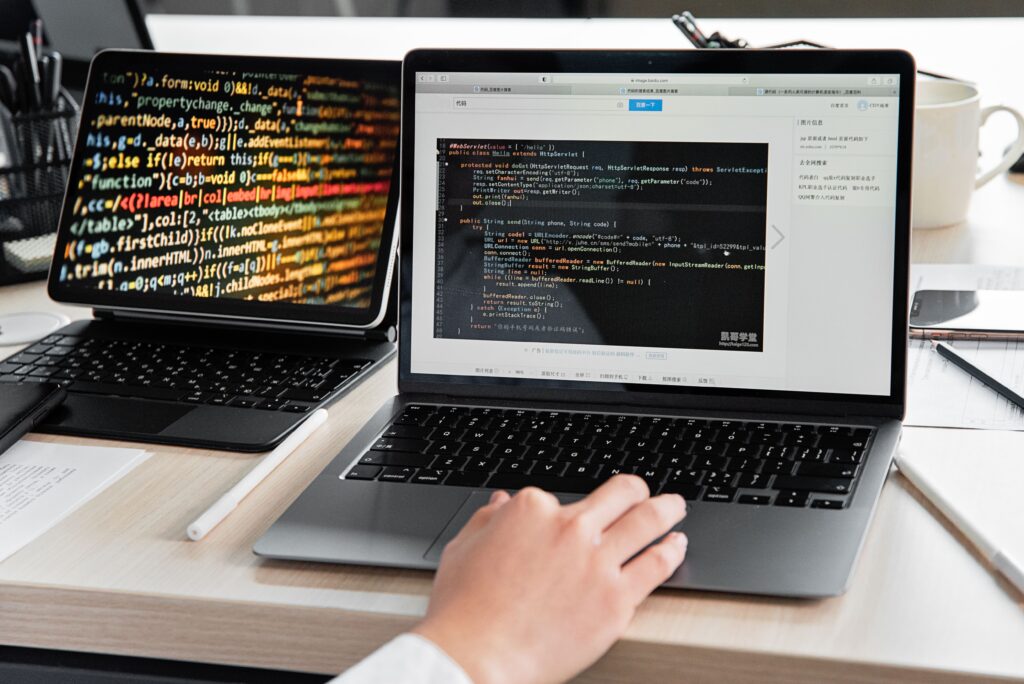 Developer working with code on laptops during WordPress website maintenance